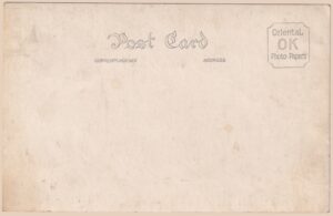 Sepiagetönte Real-Photo-Postkarte (RPPC) einer protestantischen Missionskirche in ländlichem Japan, Meiji- bis frühe Showa-Zeit (ca. 1890er–1930er Jahre): Der holzverkleidete Bau verbindet neugotisch-westliche Elemente – schmale gotische Spitzbogenfenster, giebelbekrönter Eingangsvorbau und ein kleines offenes Glockentürmchen (Dachreiter) mit spitzem Helm auf dem Dachfirst – mit typisch japanischen Konstruktionsmerkmalen wie leicht ausgestellten Dachkanten und Holz-Putzbauweise. Links steht ein verbundenes Nebengebäude, vermutlich Pfarrhaus, Schulraum oder Gemeinschaftssaal einer christlichen Missionsstation; kahle Winterbäume rahmen die Szene, ein hölzerner Telegrafenmast ragt zentral empor. Die Rückseite bestätigt die japanische Herkunft eindeutig: Die Karte wurde auf „Oriental OK Photo Papers" der Oriental Photo Industrial Co., Ltd. (Tokio, gegründet 1919) abgezogen – ein Fotopapier, das hauptsächlich in den 1920er bis 1930er Jahren (Taishō- bis frühe Shōwa-Zeit) für echte Fotopostkarten verwendet wurde. Ungelaufen und unbeschrieben, dokumentiert diese RPPC in warmer Sepiatönung ein seltenes Zeitzeugnis früher Missionsarchitektur in Japan – ein Sammlerstück für Freunde von RPPC-, Japan- und Architektur-Motiven.
