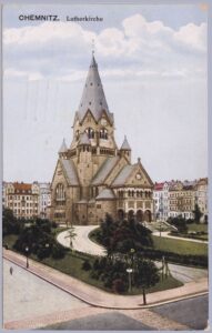 Kolorierte Ansichtskarte der Chemnitzer Lutherkirche, eines neuromanischen Sandsteinbaus mit markantem achteckigem Turm und Pyramidenhelm, herausgegeben vom Verlag Martin & Fischer, Chemnitz (Nr. 71735). Die gelaufene Karte trägt eine grüne 5-Pfennig-Germania-Marke des Deutschen Reichs und drei klare Chemnitz-Poststempel vom 2. August 1914 – dem zweiten Tag der Mobilmachung zum Ersten Weltkrieg. Ein bewegender post- und zeitgeschichtlicher Beleg aus den ersten Kriegstagen mit handschriftlicher Nachricht eines Vaters aus der Kaserne an seinen Sohn.
